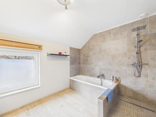 ein Badezimmer mit Badewanne und Fenster in der Unterkunft Chez Isaline Libin in Libin
