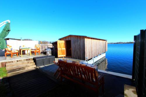 a bench sitting on a dock next to the water at FERIENHAUS SEENSUCHT in Malchow