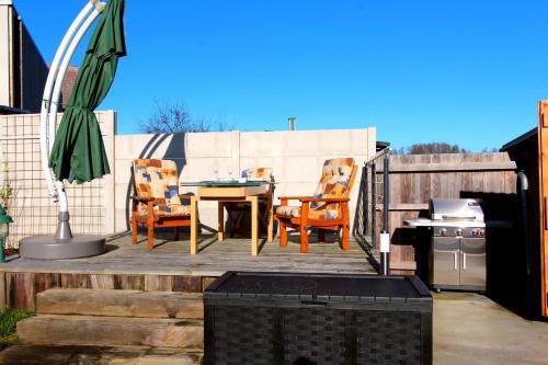 a patio with a table and chairs and an umbrella at FERIENHAUS SEENSUCHT in Malchow