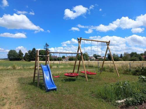 a playground with three swings in a field at Ferienwohnung Thomas in Landsberg am Lech