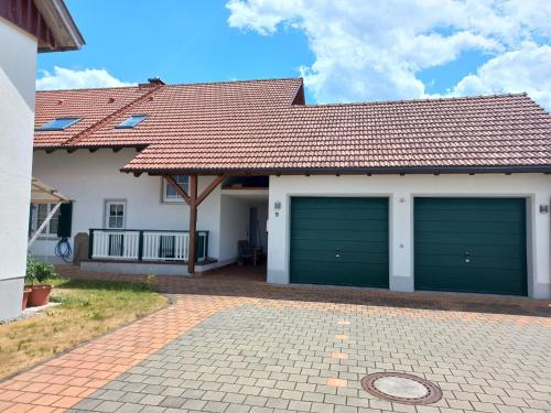 a house with two garage doors in a driveway at Ferienwohnung Thomas in Landsberg am Lech