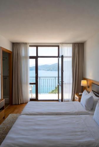 a bedroom with a large bed with a large window at Otel Ustabaş in Hopa