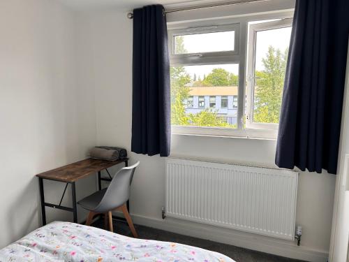 a bedroom with a bed and a desk and a window at Park Street Accommodation Room 6 in Luton