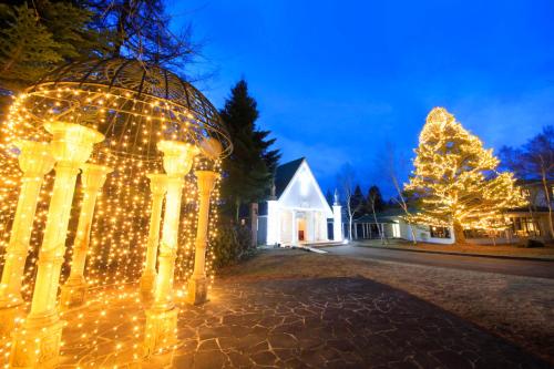 a house with christmas lights and a christmas tree at Yutorelo Karuizawa Hotel in Karuizawa