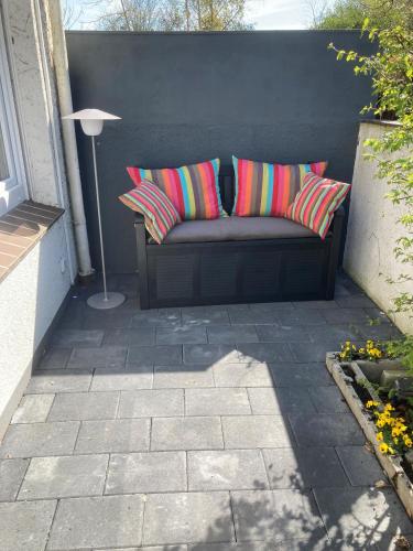 a couch with colorful pillows sitting on a patio at Dorle`s Huus in Nordhorn