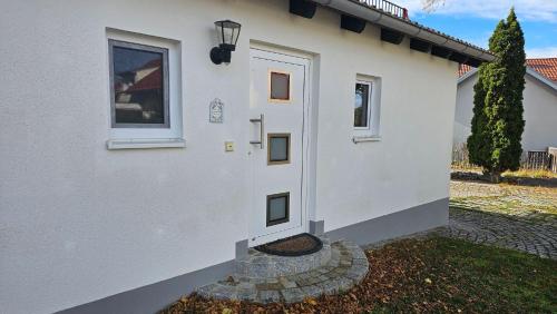 a white house with a door and a window at Ferienhaus Meli in Pürgen