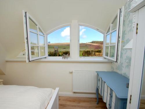 a bedroom with a bed and a large window at MR Landhaus Uhlenhof 5 in Groß Zicker