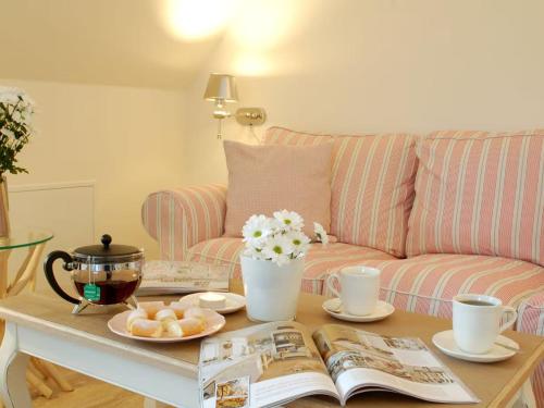 a coffee table with a book and a couch at MR Landhaus Uhlenhof 5 in Groß Zicker