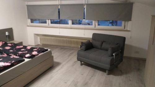a bedroom with a bed and a chair and windows at Sweet Home Longarone in Longarone
