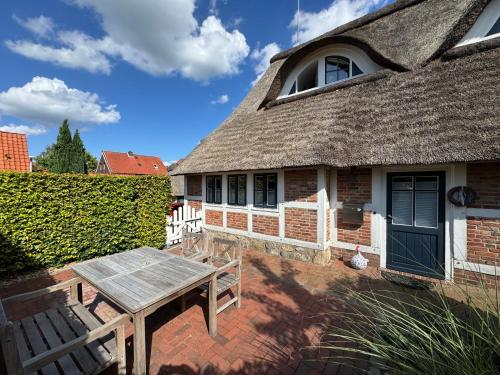 a house with a bench and a thatch roof at Ferien unterm Reetdach in Stade