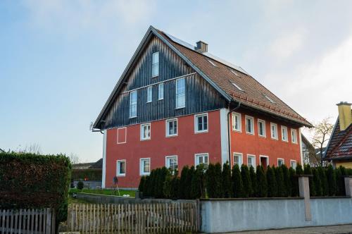 a large red house with a black roof at Ferienwohnung Demmelbach in Weil