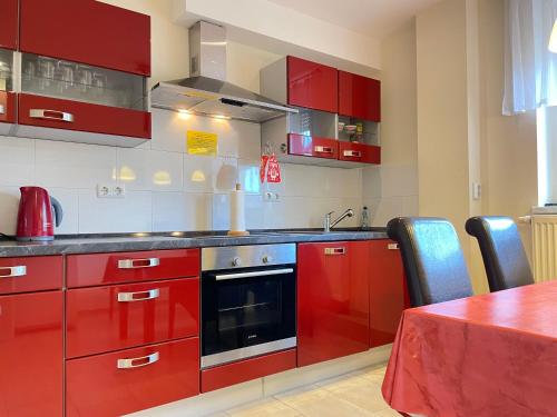 a red kitchen with red cabinets and a table at Zimmer & Ferienwohnung Steuer in Leippe