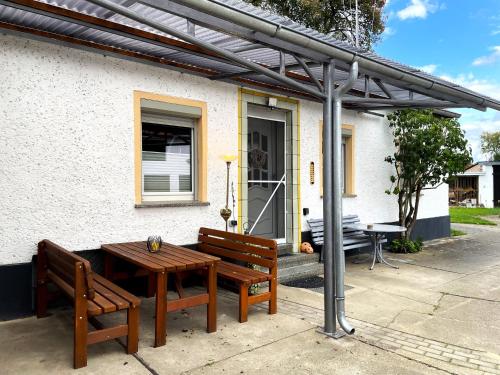 two benches and a table in front of a house at Zimmer & Ferienwohnung Steuer in Leippe
