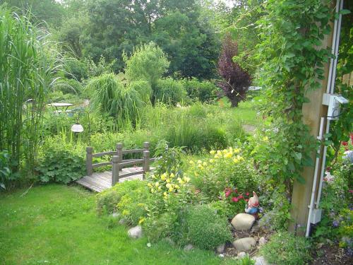 a garden with a wooden bench in the grass at Ferienwohnung Kugler in Grafrath