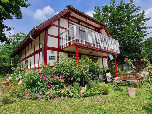 a small house with a lot of flowers in front of it at Die Wohlfühloase in Frankenau