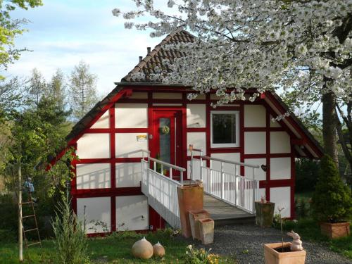 a red and white tiny house with a red door at Die Wohlfühloase in Frankenau