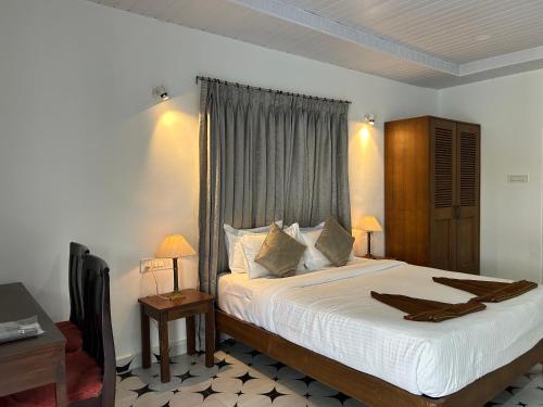 a bedroom with a bed with white sheets and a window at DD cottages Mandrem Goa in Mandrem
