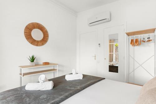 a white bedroom with two towels on a bed at Villa Artemis piscine Golfe St-Trop in Grimaud