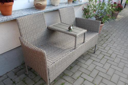 a wicker chair with a table on a patio at Ferienwohnung "Feldblick" Schuhmacher in Gützkow