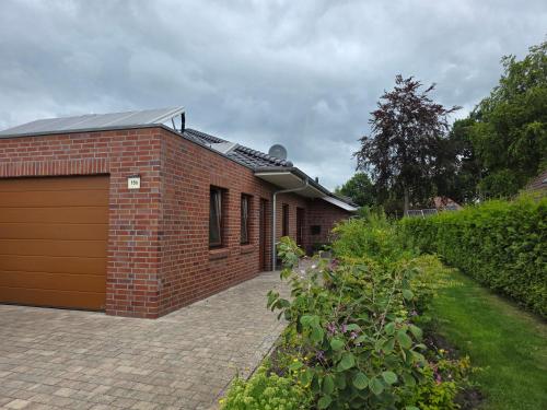 a red brick building with a garage at Haus Gartenglück in Barßel