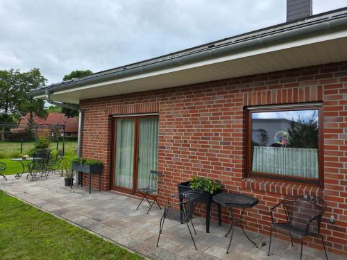 a patio with chairs and tables and a window at Haus Gartenglück in Barßel