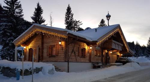 a log cabin in the snow with christmas lights at Haus Walina in Tannheim