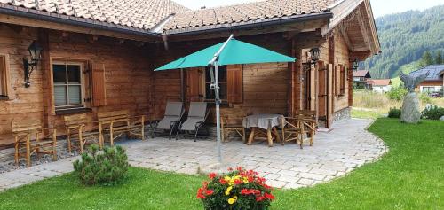 a house with a patio with a table and an umbrella at Haus Walina in Tannheim