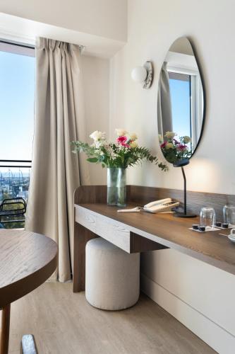 a room with a desk with a mirror and flowers at Metaxa Hotel Heraklion - Urban Boutique Living in Heraklio