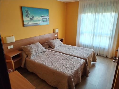 a hotel room with a bed and a window at Pensión Teyma in Ponteceso