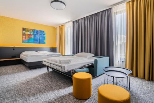a hospital room with two beds and a table and chairs at EA Congress Hotel Aldis in Hradec Králové