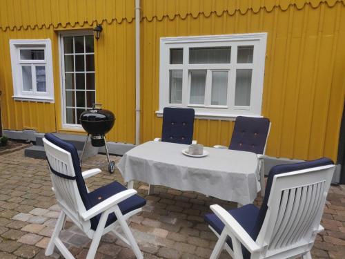a table and chairs on a patio next to a yellow building at Ferienhaus Salamander inkl Sauna in Wildemann