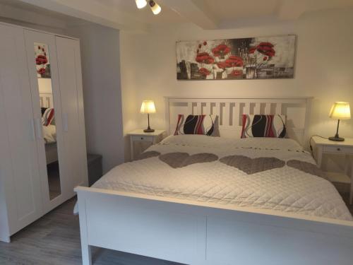 a bedroom with a bed with two lamps and a mirror at Ferienhaus Salamander inkl Sauna in Wildemann