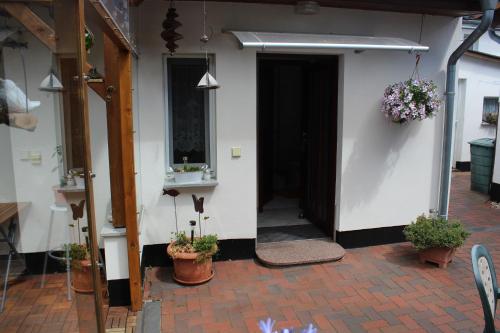 an open door of a building with potted plants at Ferienzimmer Riesebeck in Wieck