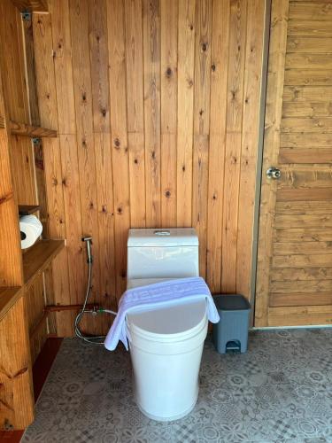 a bathroom with a toilet in a wooden wall at Hillbilly Farm in Ban Kok Kabok