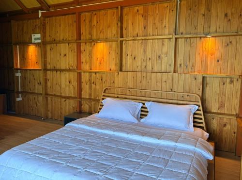 a bedroom with a bed in a wooden wall at Hillbilly Farm in Ban Kok Kabok
