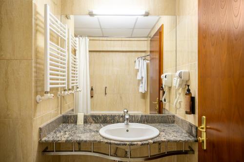 a bathroom with a sink and a mirror at Hotel Traian in Brăila