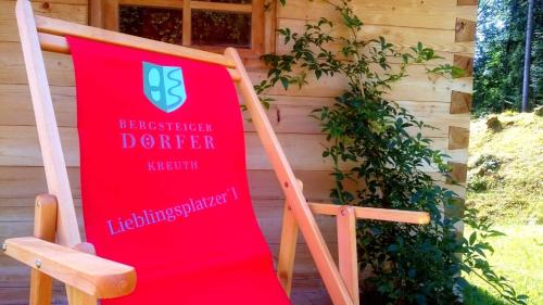 a red sign sitting on a chair in front of a building at Ferienwohnungen Kimpfbeck, Kreuth-Schärfen in Kreuth