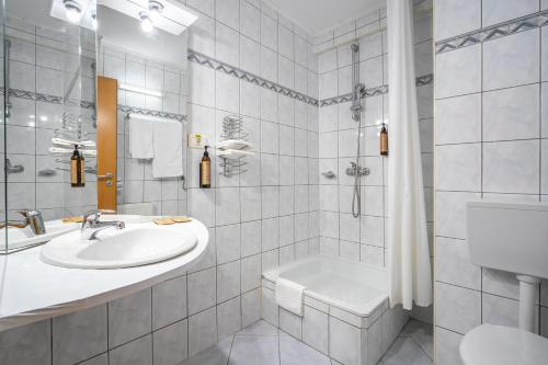 a white bathroom with a sink and a shower at Hotel Egreta in Tulcea
