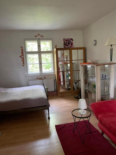 a bedroom with a bed and a red couch at Radstation Menz in Menz