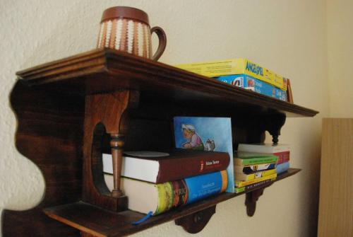 a book shelf with books and a stack thereof at Ferienwohnung Braunschweiger Hof in Halberstadt