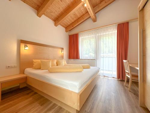 a bedroom with a bed and a desk and a window at Appartement Leiter in Niederthai