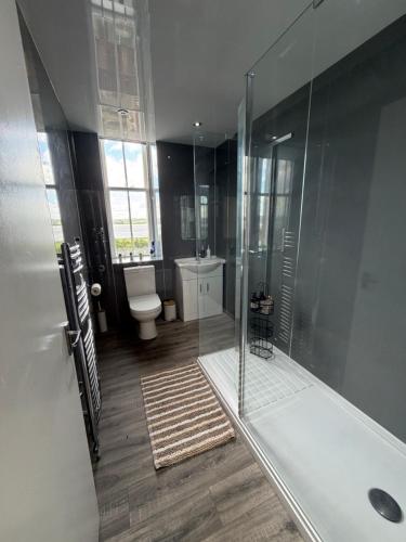 a bathroom with a shower and a toilet at Prime Dundee West End 3BR Apartment, Stunning River Views, Sleeps 6 in Dundee