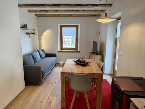 a living room with a table and a couch at Alpine Grace in Falcade