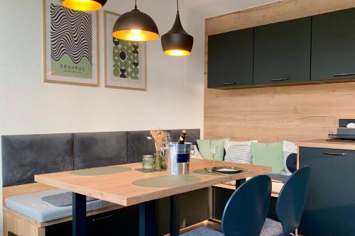 a kitchen with a wooden table and blue chairs at Turmquartier Weinsberg in Weinsberg
