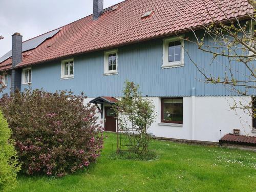 a blue and white house with a red roof at Ferienwohnung Wagner in Stiege