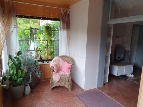 a room with a wicker chair with a pink pillow at Ferienwohnung Wagner in Stiege
