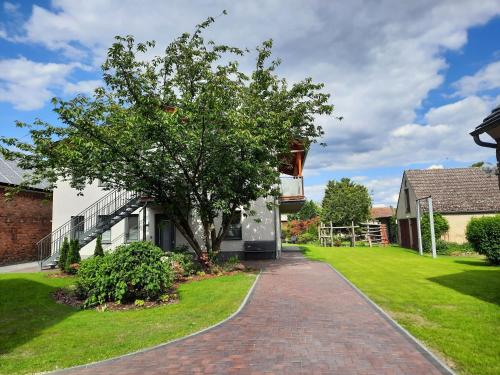 a house with a tree and a brick driveway at Ferienwohnung im Spreewald - Natur Pur in Lübben