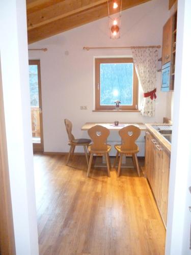 a kitchen and dining room with a table and chairs at Isidorhof in Dobbiaco