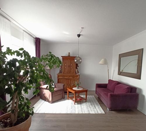 a living room with a purple couch and a table at Fewo Apfel Striep in Steinkirchen