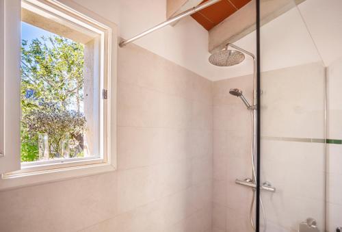 a bathroom with a shower and a window at Can Miquel, villa in Pollensa in Pollença